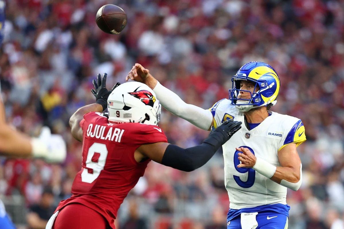 Dec 7, 2025; Glendale, Arizona, USA; Los Angeles Rams quarterback Matthew Stafford (9) throws a pass against Arizona Cardinals linebacker BJ Ojulari (9) during the second half at State Farm Stadium. Mandatory Credit: Mark J. Rebilas-Imagn Images