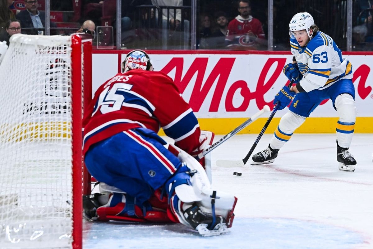 Dec 7, 2025; Montreal, Quebec, CAN; St. Louis Blues left wing Jake Neighbours (63) plays the puck against Montreal Canadiens goalie Jakub Dobes (75) during the second period at Bell Centre. Mandatory Credit: David Kirouac-Imagn Images