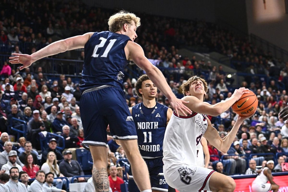 Dec 7, 2025; Spokane, Washington, USA; Gonzaga Bulldogs guard Davis Fogle (4) shoots the ball against North Florida Ospreys forward Dalton Gayman (21) in the second half at McCarthey Athletic Center. Mandatory Credit: James Snook-Imagn Images