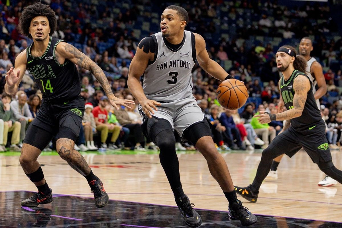 Dec 8, 2025; New Orleans, Louisiana, USA;  San Antonio Spurs forward/guard Keldon Johnson (3) dribbles against New Orleans Pelicans guard/forward Micah Peavy (14) during the first half at Smoothie King Center. Mandatory Credit: Stephen Lew-Imagn Images