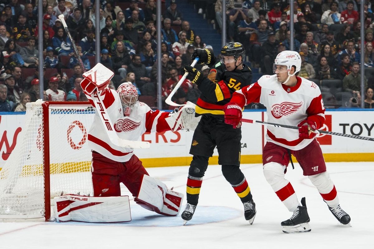 Dec 8, 2025; Vancouver, British Columbia, CAN; Detroit Red Wings defenseman Ben Chiarot (8) and Vancouver Canucks forward Aatu Raty (54) watch as goalie John Gibson (36) makes a save in the second period at Rogers Arena. Mandatory Credit: Bob Frid-Imagn Images