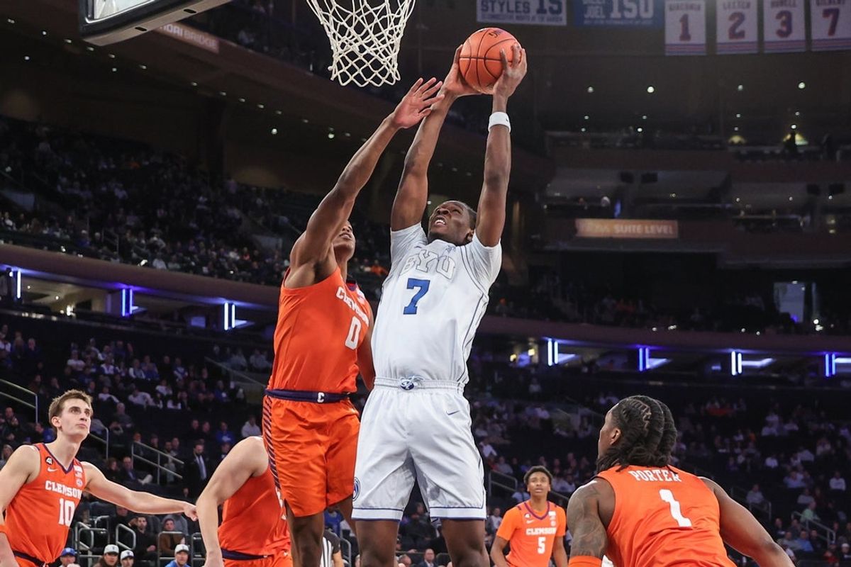 Dec 9, 2025; New York, New York, USA;  BYU Cougars forward Khadim Mboup (7) looks to drive past Clemson Tigers forward RJ Godfrey (0) in the first half at Madison Square Garden. Mandatory Credit: Wendell Cruz-Imagn Images