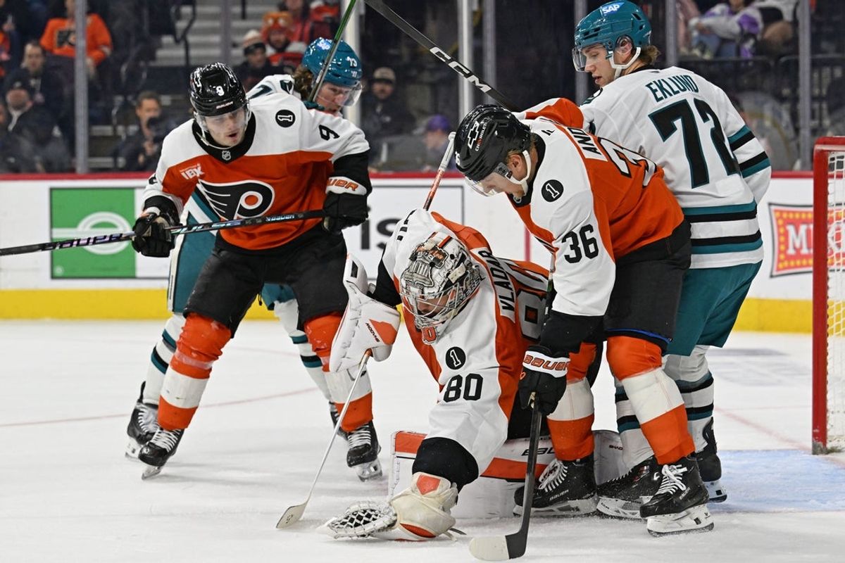 Dec 9, 2025; Philadelphia, Pennsylvania, USA; Philadelphia Flyers goaltender Dan Vladar (80) covers the puck with help from defenseman Jamie Drysdale (9) and defenseman Emil Andrae (36) against the San Jose Sharks during the second period at Xfinity Mobile Arena. Mandatory Credit: Eric Hartline-Imagn Images