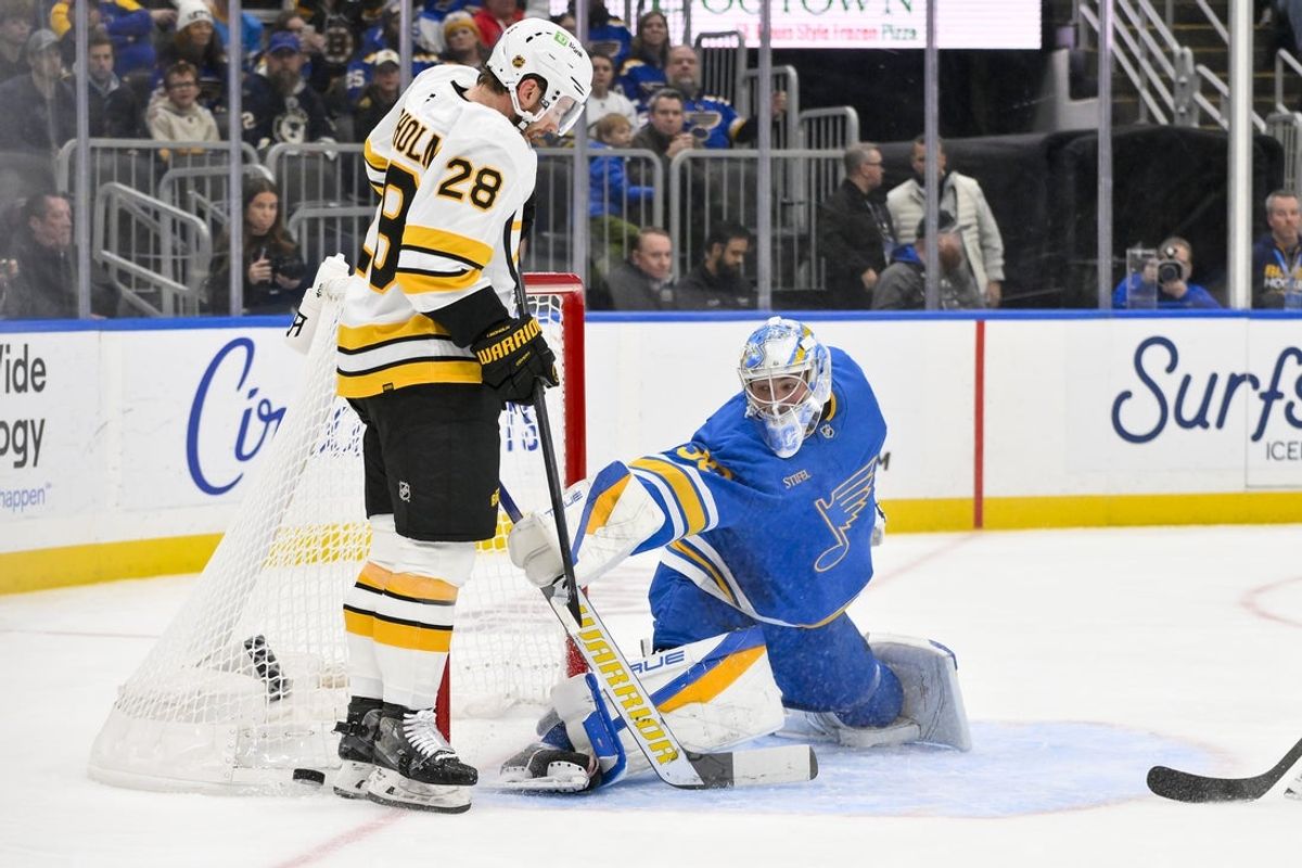 Dec 9, 2025; St. Louis, Missouri, USA; St. Louis Blues goaltender Joel Hofer (30) defends the net against Boston Bruins center Elias Lindholm (28) during the first period at Enterprise Center. Mandatory Credit: Jeff Curry-Imagn Images