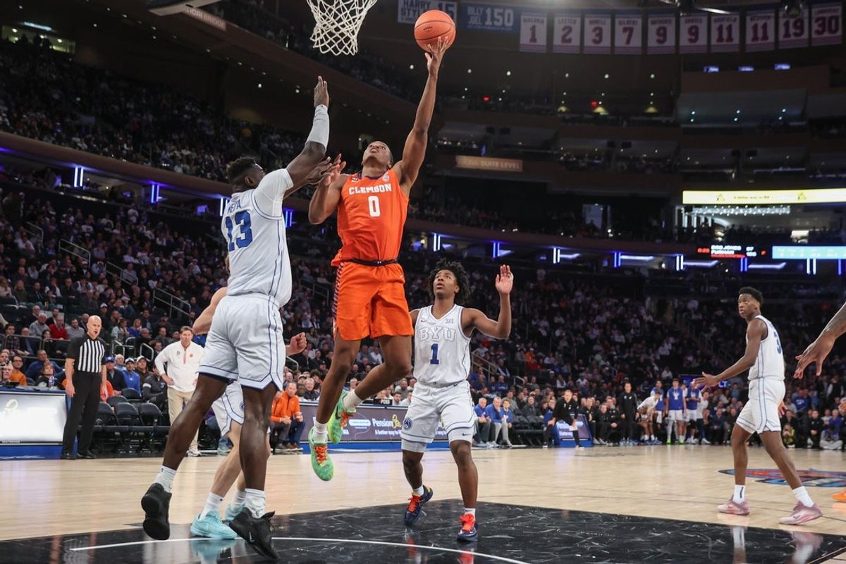 Dec 9, 2025; New York, New York, USA;  Clemson Tigers forward RJ Godfrey (0) looks to drive past BYU Cougars center Keba Keita (13) in the second half at Madison Square Garden. Mandatory Credit: Wendell Cruz-Imagn Images