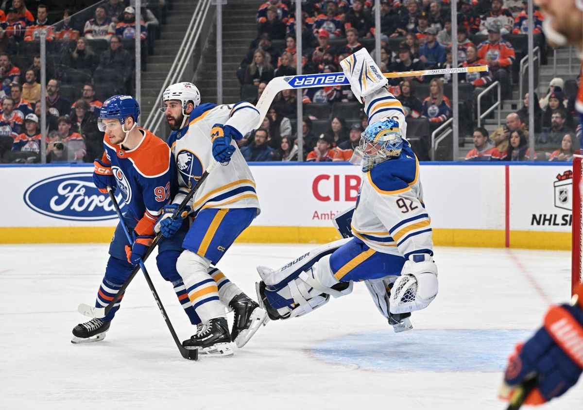 Dec 9, 2025; Edmonton, Alberta, CAN; Edmonton Oilers right winger Vasily Podkolzin (92) and Buffalo Sabres defenseman Connor Timmins 21) battle for the puck in front of goalie Colten Ellis (92) during the first period at Rogers Place. Mandatory Credit: Walter Tychnowicz-Imagn Images