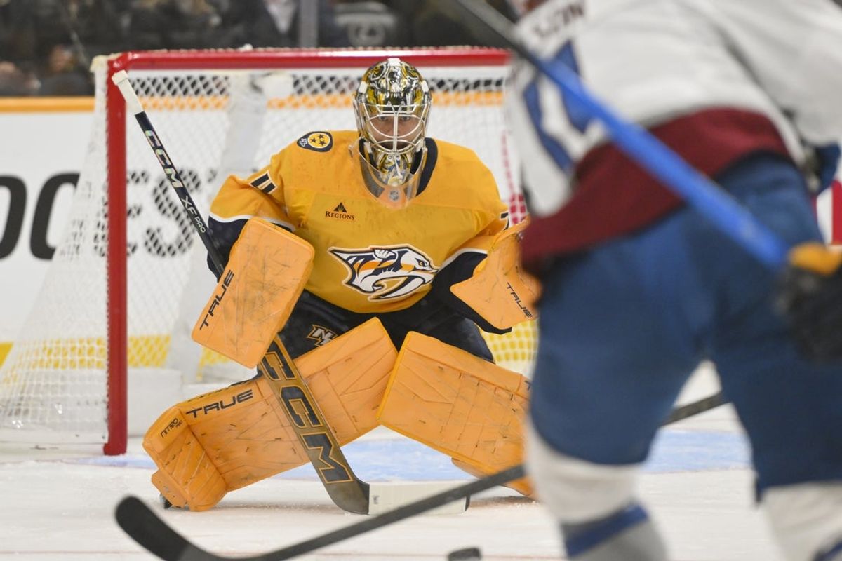 Dec 9, 2025; Nashville, Tennessee, USA;  Nashville Predators goaltender Juuse Saros (74) watches the shot of Colorado Avalanche center Brock Nelson (11) during the first period at Bridgestone Arena. Mandatory Credit: Steve Roberts-Imagn Images