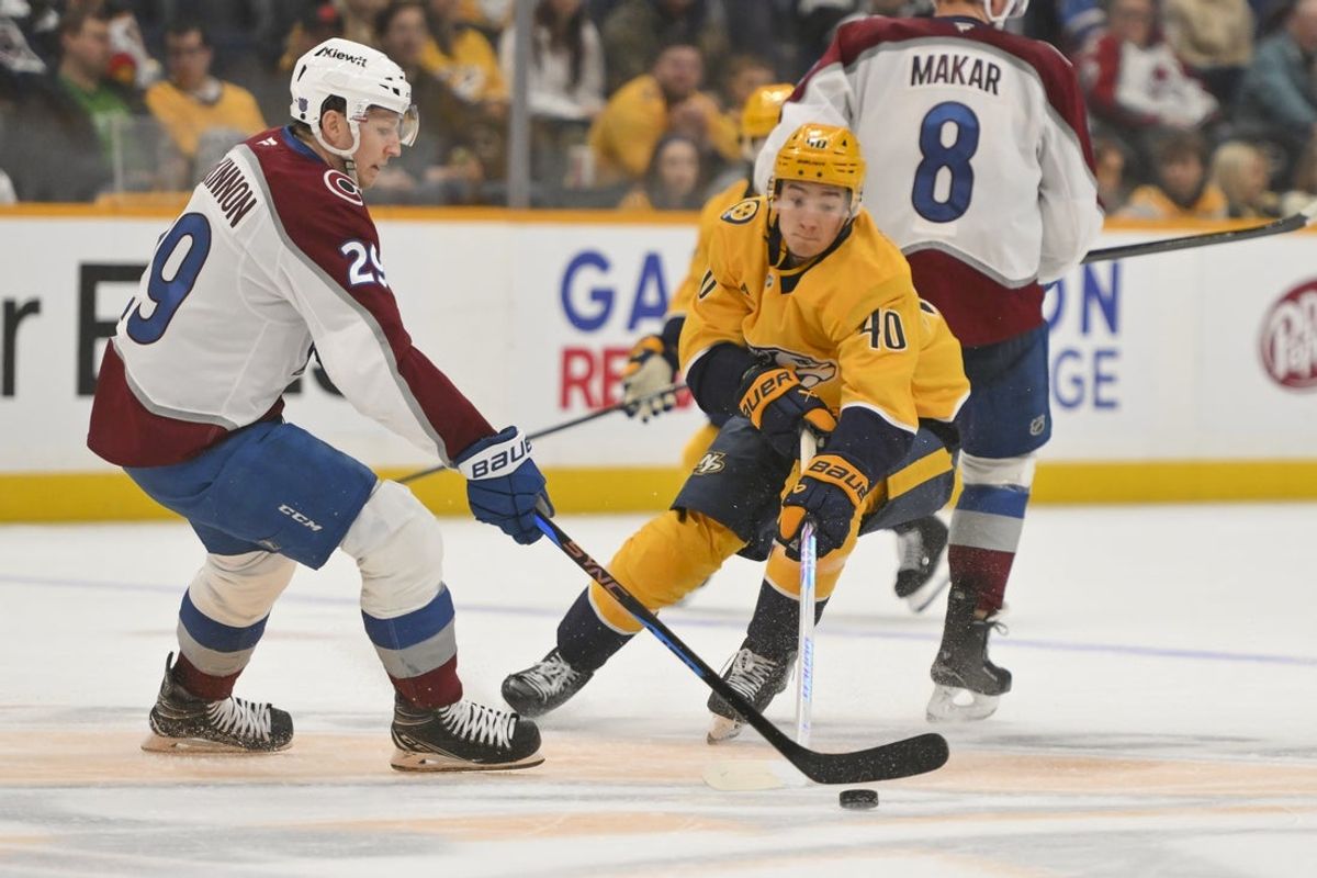 Dec 9, 2025; Nashville, Tennessee, USA;  Nashville Predators center Fedor Svechkiv (40) battles Colorado Avalanche center Nathan MacKinnon (29) for the puck during the second period at Bridgestone Arena. Mandatory Credit: Steve Roberts-Imagn Images