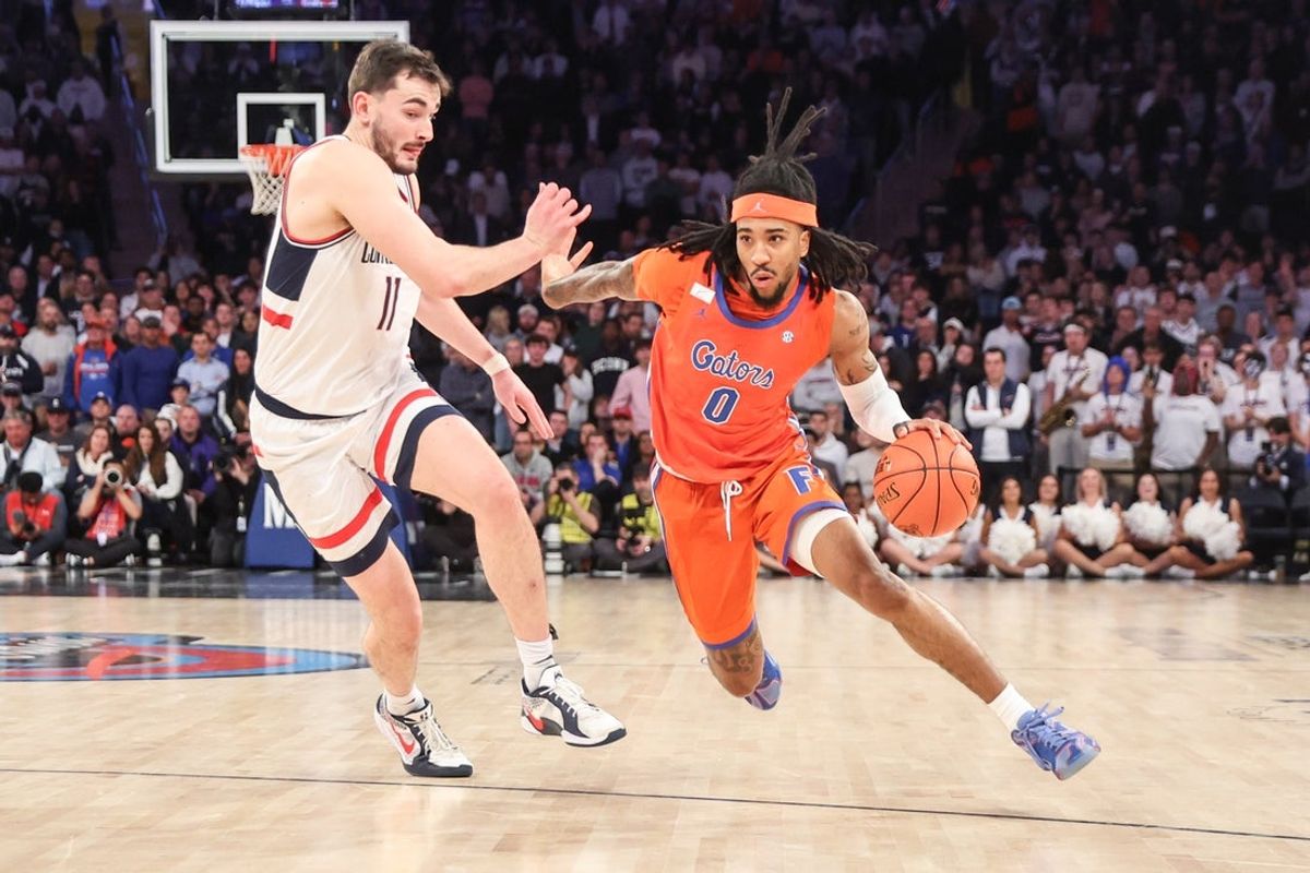 Dec 9, 2025; New York, New York, USA;  Florida Gators guard Boogie Fland (0) drives past UConn Huskies forward Alex Karaban (11) in the second half at Madison Square Garden. Mandatory Credit: Wendell Cruz-Imagn Images