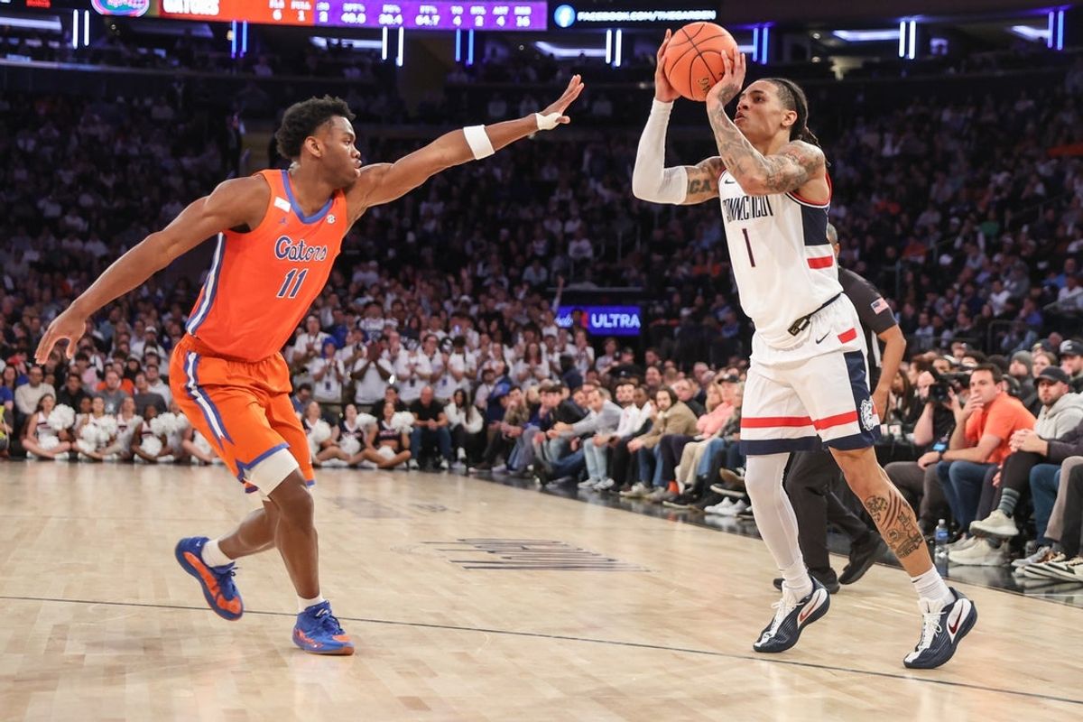 Dec 9, 2025; New York, New York, USA;  UConn Huskies guard Solo Ball (1) shoots past Florida Gators guard CJ Ingram II (11) in the first half at Madison Square Garden. Mandatory Credit: Wendell Cruz-Imagn Images