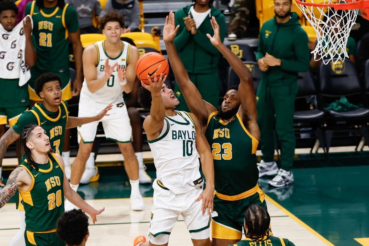 Dec 10, 2025; Waco, Texas, USA; Baylor Bears guard Isaac Williams (10) shoots as Norfolk State Spartans forward Keyontae Lewis (23) defends during the first half at Paul and Alejandra Foster Pavilion. Mandatory Credit: Chris Jones-Imagn Images