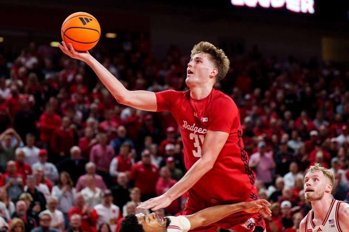 Dec 10, 2025; Lincoln, Nebraska, USA; Wisconsin Badgers forward Nolan Winter (31) fouls against Nebraska Cornhuskers guard Jamarques Lawrence (10) during the second half at Pinnacle Bank Arena. Mandatory Credit: Dylan Widger-Imagn Images