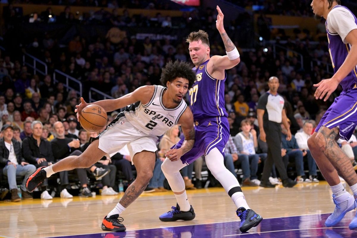 Dec 10, 2025; Los Angeles, California, USA;  San Antonio Spurs guard Dylan Harper (2) is defended by Los Angeles Lakers guard Luka Doncic (77) as he drives to the basket during the first half at Crypto.com Arena. Mandatory Credit: Jayne Kamin-Oncea-Imagn Images