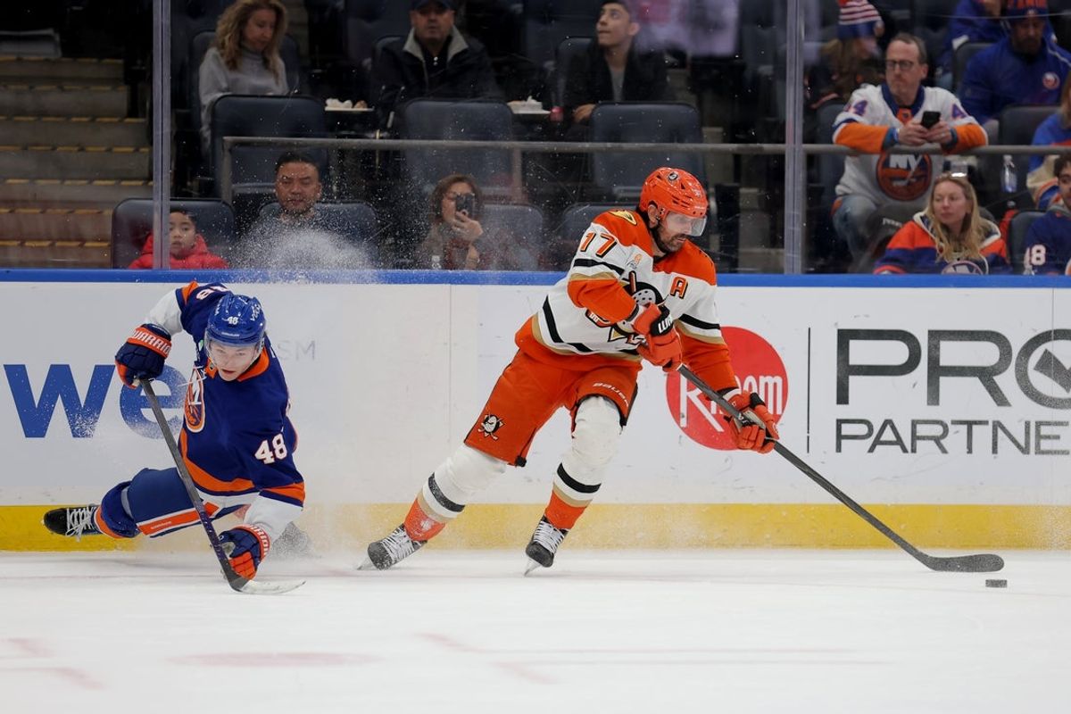Dec 11, 2025; Elmont, New York, USA; Anaheim Ducks left wing Alex Killorn (17) plays the puck against New York Islanders defenseman Matthew Schaefer (48) during the first period at UBS Arena. Mandatory Credit: Brad Penner-Imagn Images