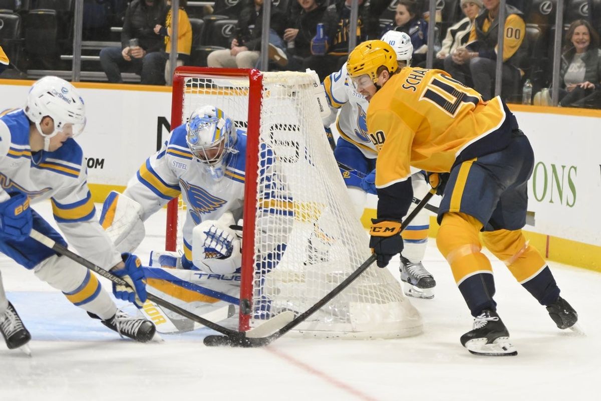 Dec 11, 2025; Nashville, Tennessee, USA;  St. Louis Blues goaltender Joel Hofer (30) blocks the shot of Nashville Predators left wing Reid Schaefer (49) during the third period at Bridgestone Arena. Mandatory Credit: Steve Roberts-Imagn Images