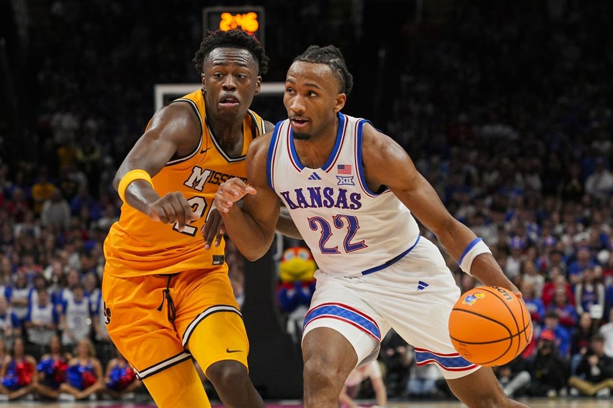 Dec 7, 2025; Kansas City, Missouri, USA; Kansas Jayhawks guard Darryn Peterson (22) drives against Missouri Tigers forward Mark Mitchell (25) during the first half at T-Mobile Center. Mandatory Credit: Jay Biggerstaff-Imagn Images