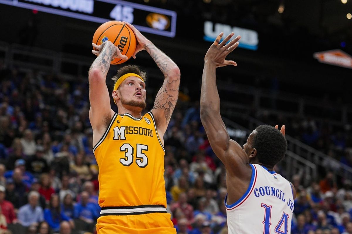 Dec 7, 2025; Kansas City, Missouri, USA; Missouri Tigers guard Jacob Crews (35) shoots against Kansas Jayhawks guard Melvin Council Jr. (14) during the second half at T-Mobile Center. Mandatory Credit: Jay Biggerstaff-Imagn Images
