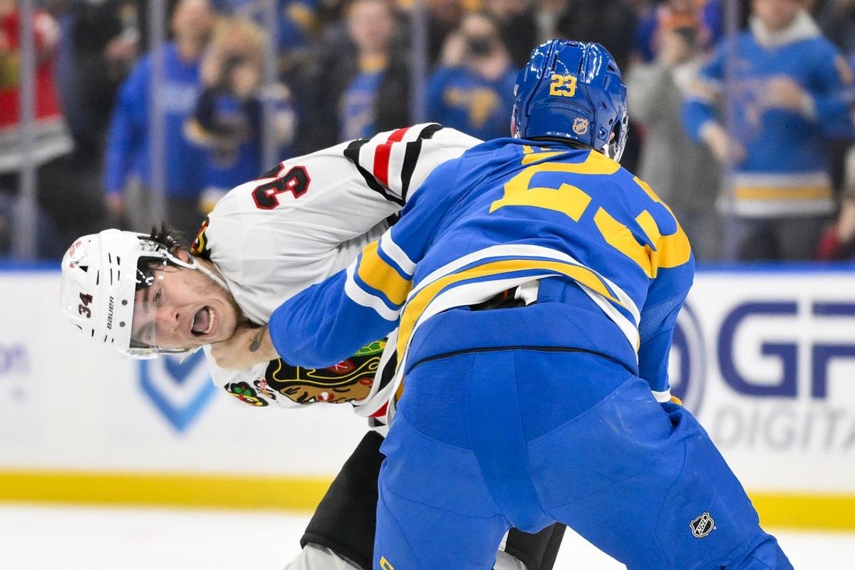 Dec 12, 2025; St. Louis, Missouri, USA; Chicago Blackhawks center Colton Dach (34) fights against St. Louis Blues defenseman Logan Mailloux (23) during the first period at Enterprise Center. Mandatory Credit: Jeff Curry-Imagn Images