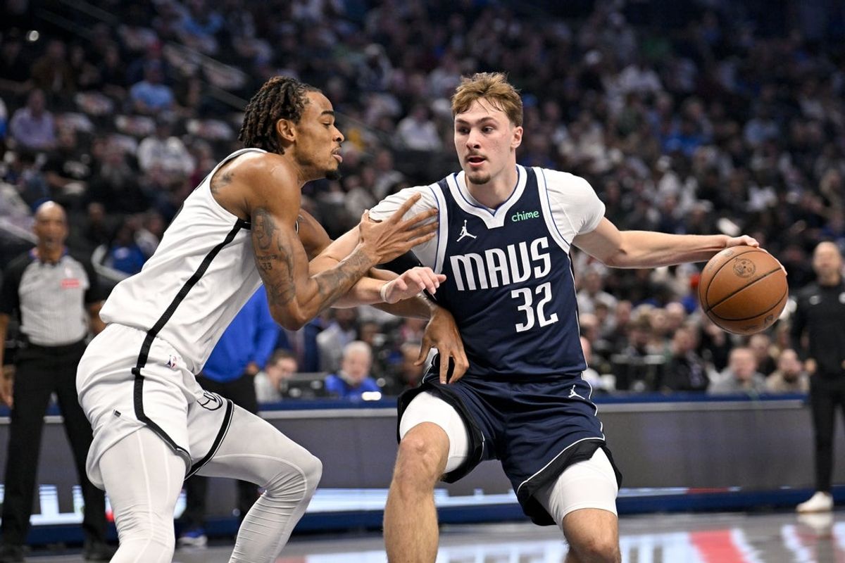 Dec 12, 2025; Dallas, Texas, USA; Dallas Mavericks forward Cooper Flagg (32) looks to move the ball past Brooklyn Nets center Nic Claxton (33) during the first quarter at the American Airlines Center. Mandatory Credit: Jerome Miron-Imagn Images