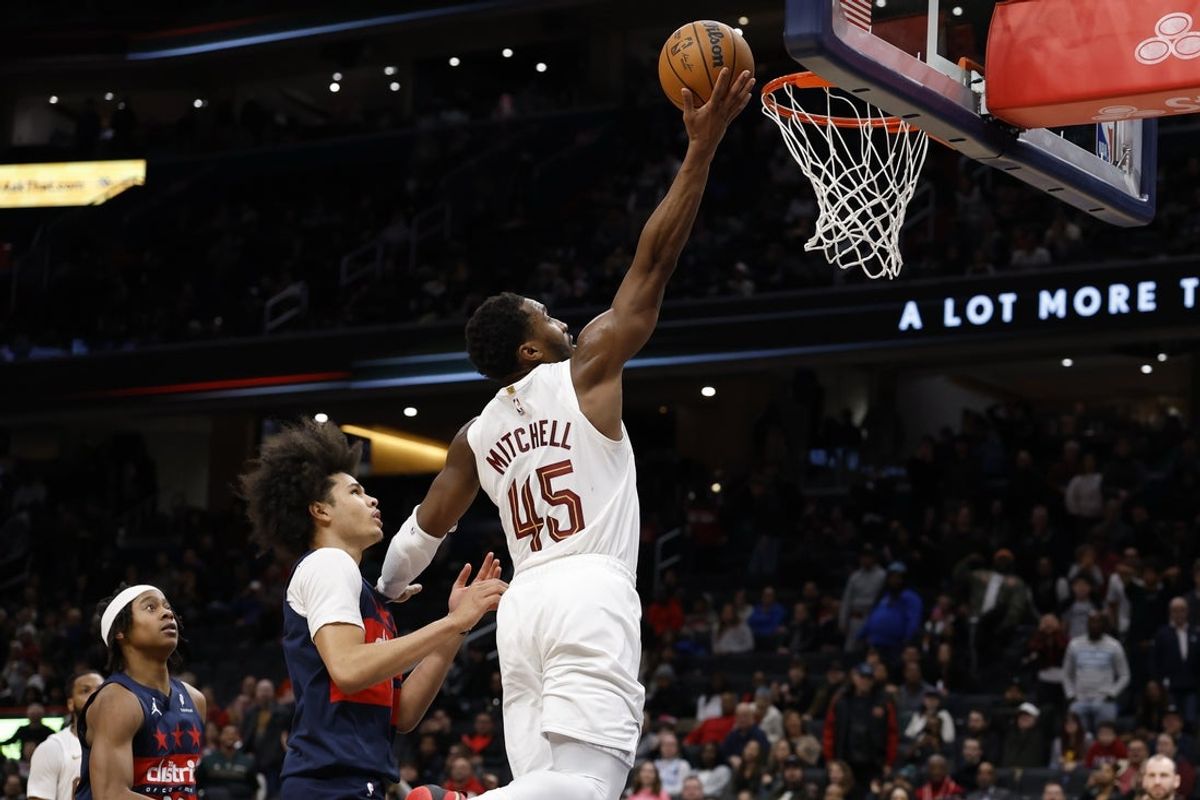 Dec 12, 2025; Washington, District of Columbia, USA; Cleveland Cavaliers guard Donovan Mitchell (45) shoots the ball as Washington Wizards forward Kyshawn George (18) chases in the fourth quarter at Capital One Arena. Mandatory Credit: Geoff Burke-Imagn Images
