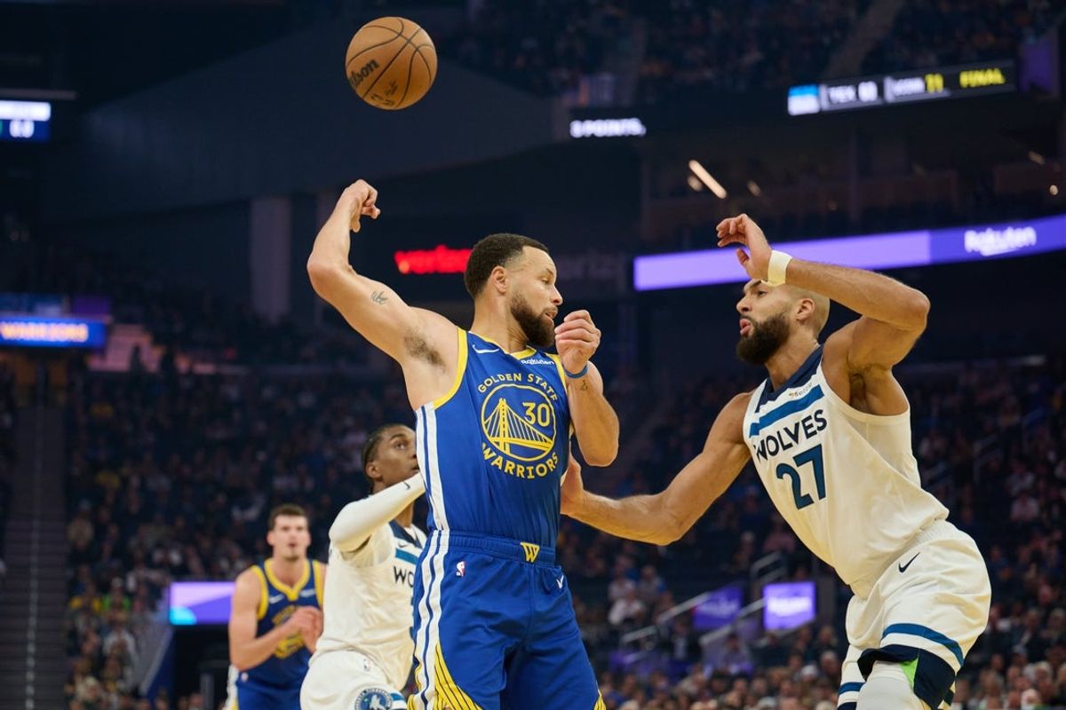 Dec 12, 2025; San Francisco, California, USA; Golden State Warriors guard Stephen Curry (30) throws a behind-the-back pass to center Quinten Post (21) against Minnesota Timberwolves center Rudy Gobert (27) during the first quarter at Chase Center. Mandatory Credit: Robert Edwards-Imagn Images