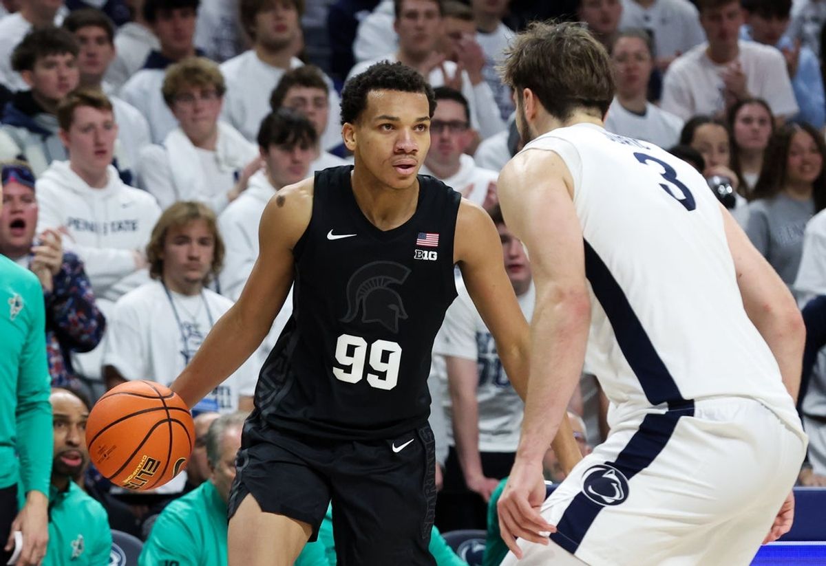 Dec 13, 2025; University Park, Pennsylvania, USA; Michigan State Spartans guard Divine Ugochukwu (99) looks to move the ball around Penn State Nittany Lions forward Ivan Juric (3) during the second half at Bryce Jordan Center. Mandatory Credit: Matthew O'Haren-Imagn Images