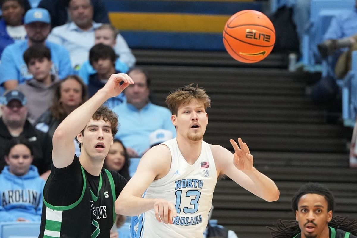 Dec 13, 2025; Chapel Hill, North Carolina, USA; North Carolina Tar Heels center Henri Veesaar (13) passes the ball as USC Upstate Spartans center Coen Collier (7) defends at Dean E. Smith Center. Mandatory Credit: Bob Donnan-Imagn Images