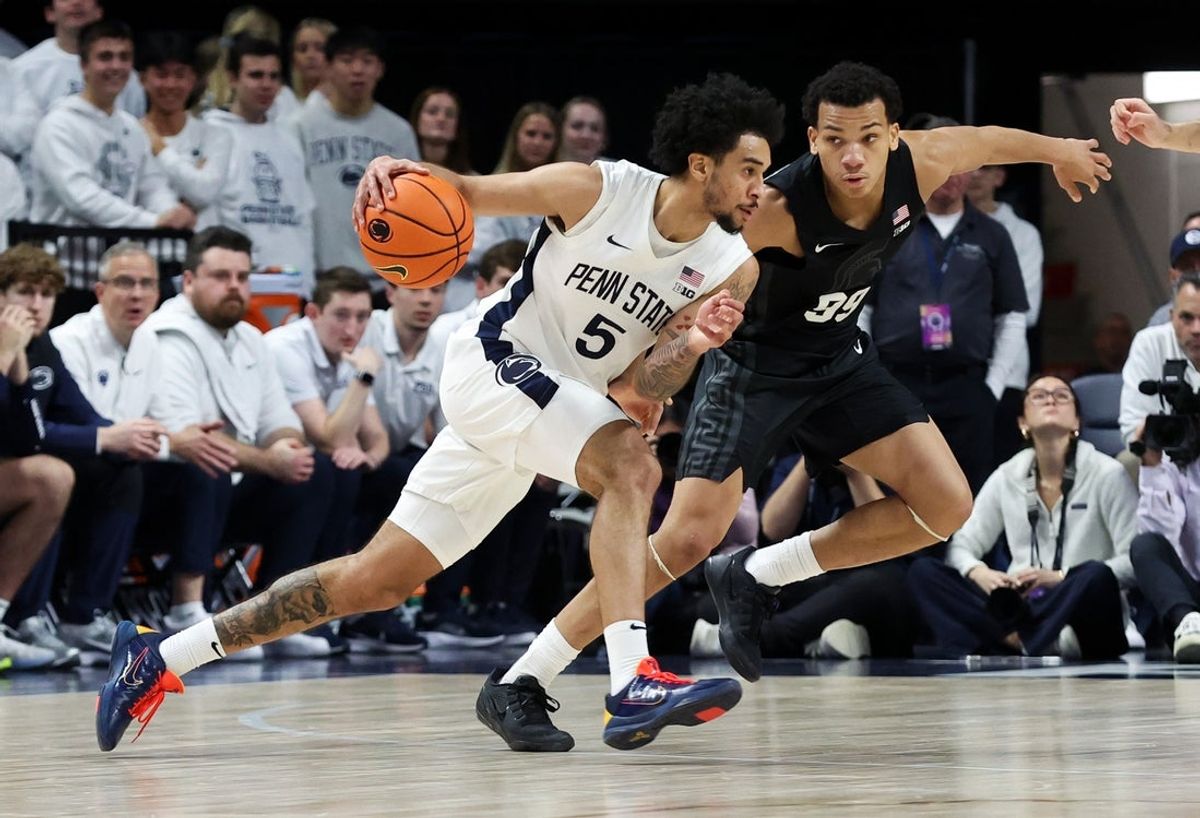 Dec 13, 2025; University Park, Pennsylvania, USA; Penn State Nittany Lions guard Freddie Dilione V (5) dribbles the ball towards the basket as Michigan State Spartans guard Divine Ugochukwu (99) defends during the second half at Bryce Jordan Center. Mandatory Credit: Matthew O'Haren-Imagn Images