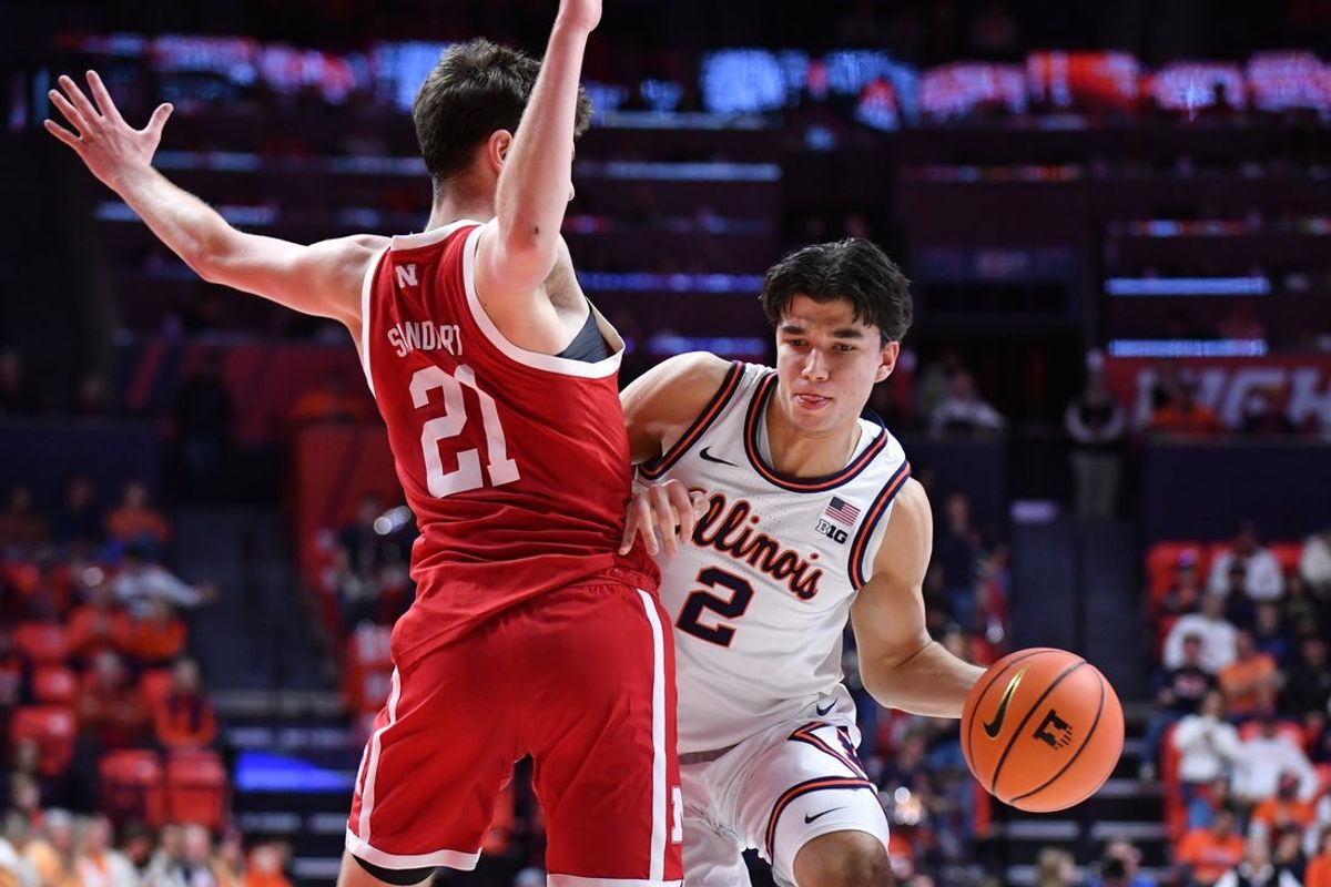 Dec 13, 2025; Champaign, Illinois, USA; Illinois Fighting Illini guard Andrej Stojakovic (2) drives the ball around Nebraska Cornhuskers forward Pryce Sandfort (21) during the first half at State Farm Center. Mandatory Credit: Ron Johnson-Imagn Images