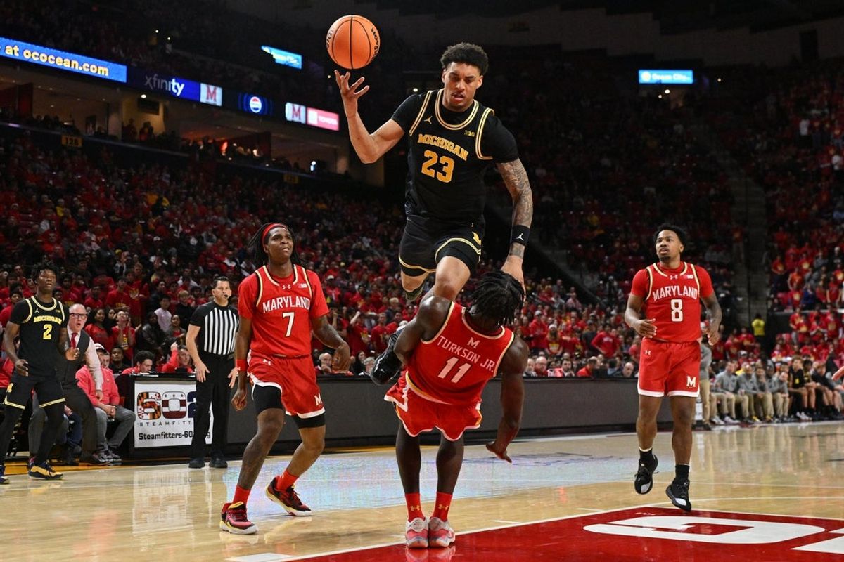 Dec 13, 2025; College Park, Maryland, USA;  Michigan Wolverines forward Yaxel Lendeborg (23) is fouled by Maryland Terrapins guard George Turkson Jr. (11) while driving to the basket in the first half at Xfinity Center. Mandatory Credit: Jamie Sabau-Imagn Images