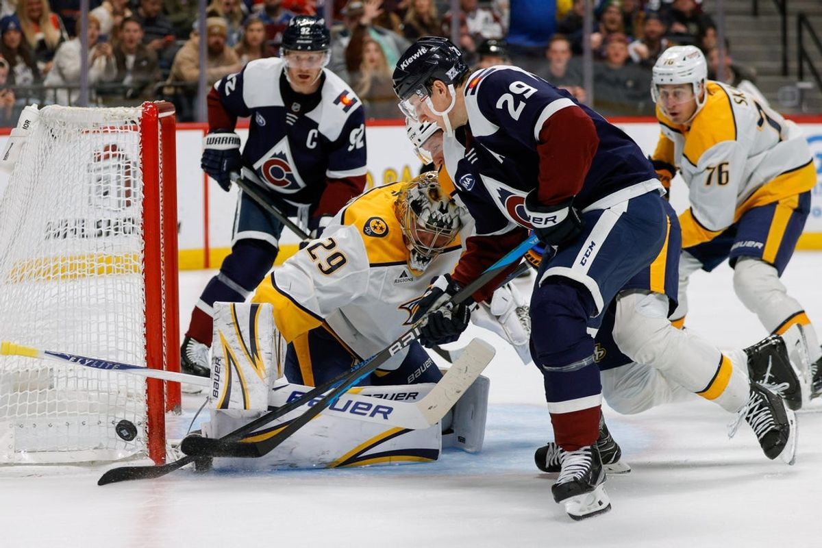 Dec 13, 2025; Denver, Colorado, USA; Colorado Avalanche center Nathan MacKinnon (29) battle for the puck with Nashville Predators right wing Michael McCarron (47) as goaltender Justus Annunen (29) defends in the second period at Ball Arena. Mandatory Credit: Isaiah J. Downing-Imagn Images