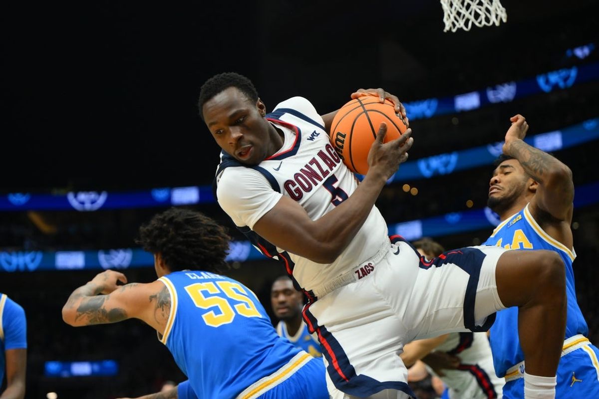 Dec 13, 2025; Seattle, Washington, USA; Gonzaga Bulldogs forward Emmanuel Innocenti (5) rebounds the ball over UCLA Bruins guard Skyy Clark (55) during the first half at Climate Pledge Arena. Mandatory Credit: Steven Bisig-Imagn Images