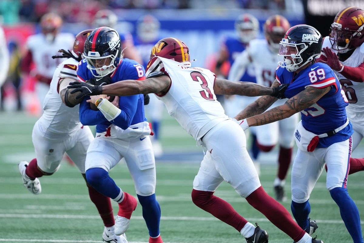 Dec 14, 2025; East Rutherford, New Jersey, USA;  New York Giants quarterback Jaxson Dart (6) runs the ball during the second quarter against Washington Commanders safety Will Harris (3) at MetLife Stadium. Mandatory Credit: Robert Deutsch-Imagn Images