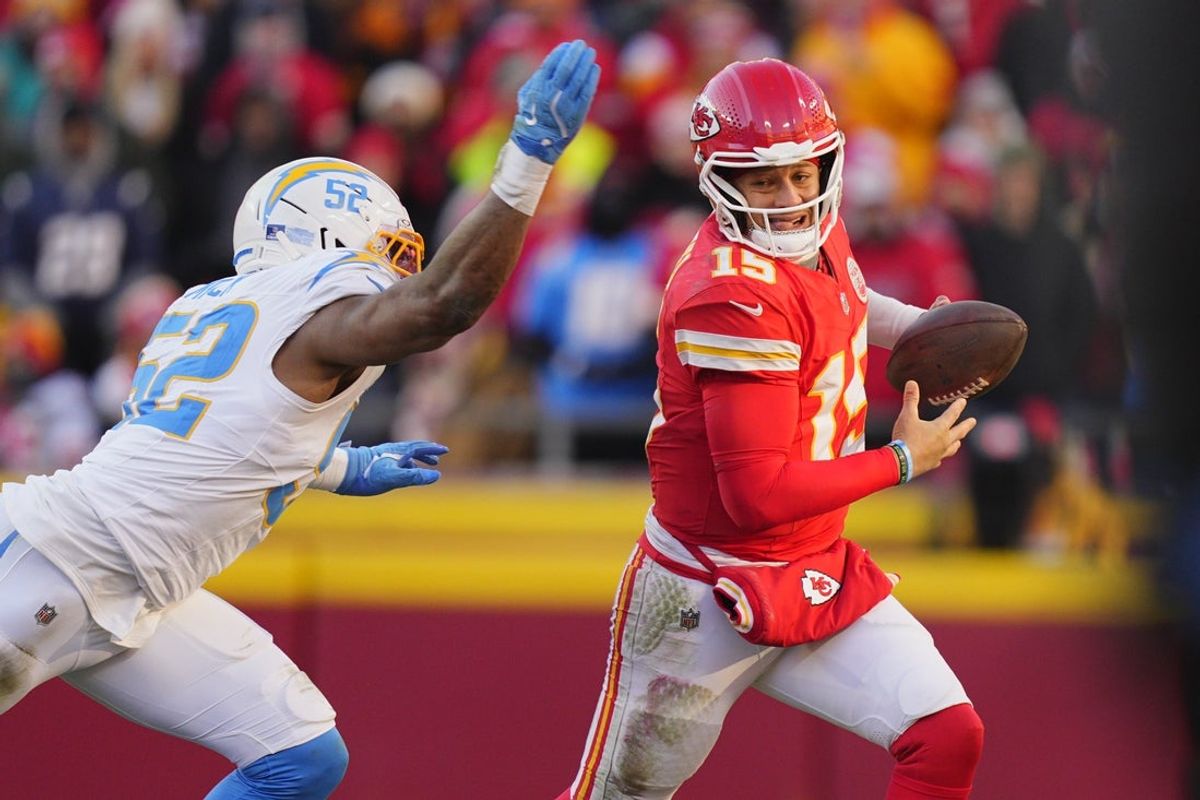 Dec 14, 2025; Kansas City, Missouri, USA; Kansas City Chiefs quarterback Patrick Mahomes (15) scrambles against Los Angeles Chargers linebacker Khalil Mack (52) during the second half at GEHA Field at Arrowhead Stadium. Mandatory Credit: Jay Biggerstaff-Imagn Images