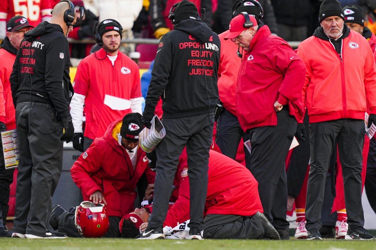 Dec 14, 2025; Kansas City, Missouri, USA; Kansas City Chiefs quarterback Patrick Mahomes (15) is attended to by team medical staff following an injury during the fourth quarter against the Los Angeles Chargers at GEHA Field at Arrowhead Stadium. Kansas City Chiefs head coach Andy Reid, second from right, watches. Mandatory Credit: Jay Biggerstaff-Imagn Images