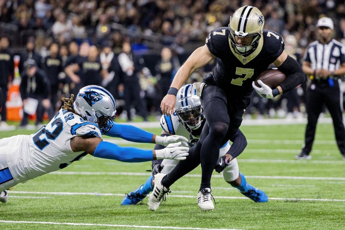 Dec 14, 2025; New Orleans, Louisiana, USA; New Orleans Saints quarterback Taysom Hill (7) avoids being tackled by Carolina Panthers linebacker Trevis Gipson (52) during the second quarter at Caesars Superdome. Mandatory Credit: Stephen Lew-Imagn Images