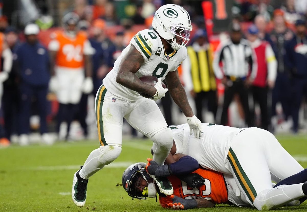 Dec 14, 2025; Denver, Colorado, USA; Green Bay Packers running back Josh Jacobs (8) runs for a gain past Denver Broncos linebacker Nik Bonitto (15) during the third quarter at Empower Field at Mile High. Mandatory Credit: Ron Chenoy-Imagn Images