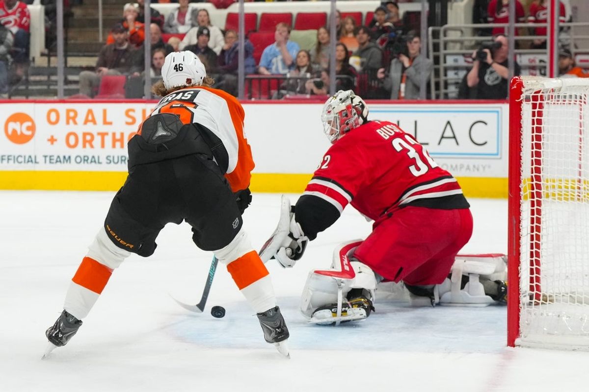 Dec 14, 2025; Raleigh, North Carolina, USA;  Carolina Hurricanes goaltender Brandon Bussi (32) stops the scoring attempt by Philadelphia Flyers center Trevor Zegras (46) during the second period at Lenovo Center. Mandatory Credit: James Guillory-Imagn Images