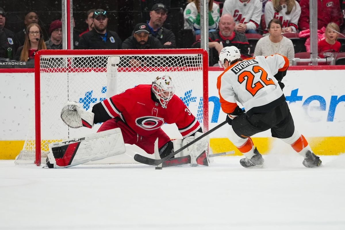 Dec 14, 2025; Raleigh, North Carolina, USA; Carolina Hurricanes goaltender Brandon Bussi (32) stops the shot by Philadelphia Flyers center Christian Dvorak (22) in the shoot out at Lenovo Center. Mandatory Credit: James Guillory-Imagn Images