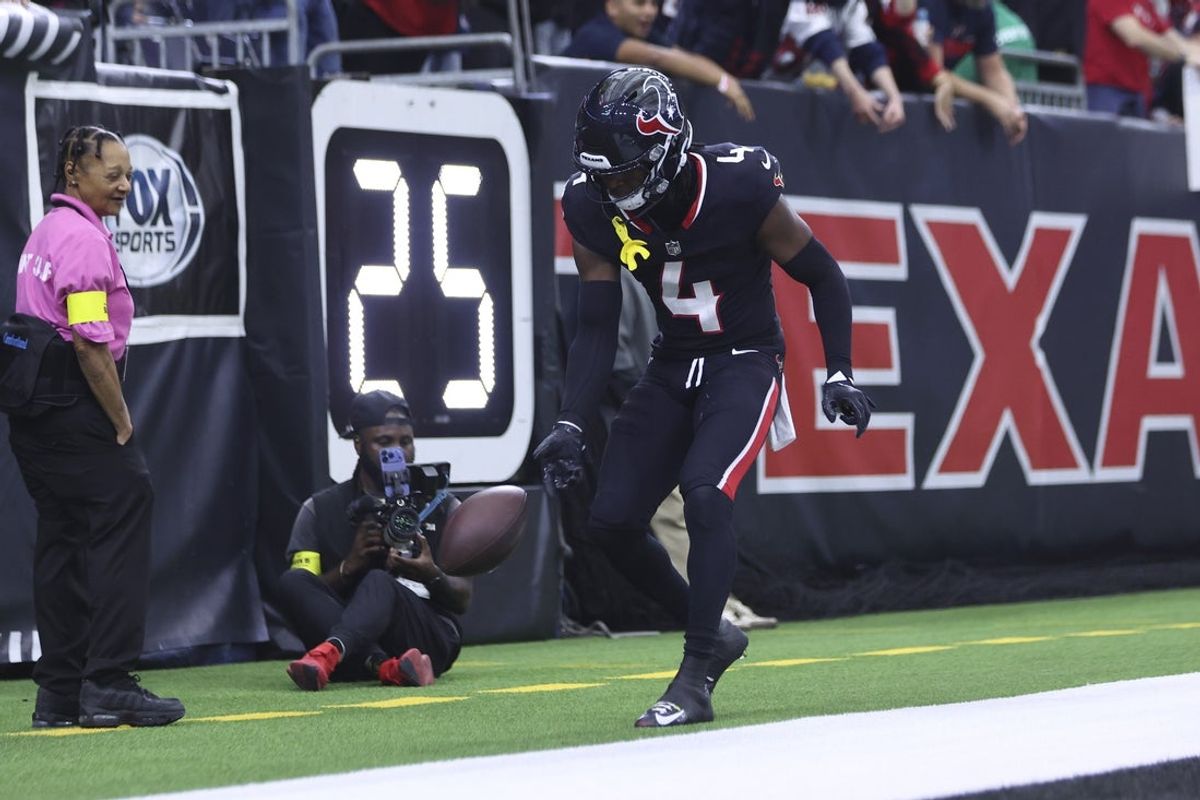 Dec 14, 2025; Houston, Texas, USA; Houston Texans cornerback Kamari Lassiter (4) spins the ball after making an interception during the game against the Arizona Cardinals at NRG Stadium. Mandatory Credit: Troy Taormina-Imagn Images