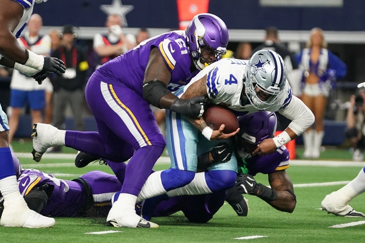 Dec 14, 2025; Arlington, Texas, USA;  Dallas Cowboys quarterback Dak Prescott (4) is tackled by Minnesota Vikings defensive tackle Jalen Redmond (61) during the first half at AT&T Stadium. Mandatory Credit: Raymond Carlin III-Imagn Images