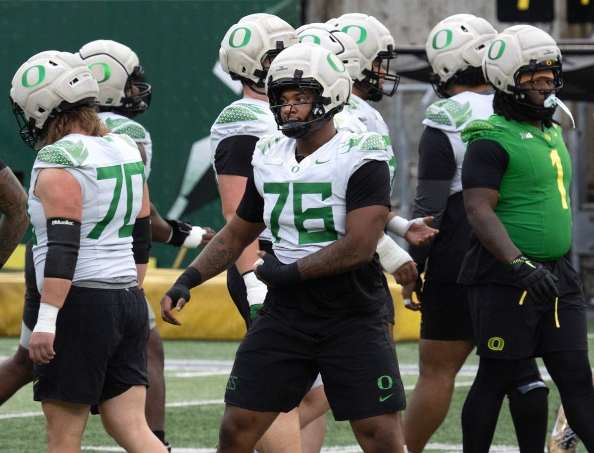Oregon’s Isaiah World, center, works out with the team during a practice session before the first-round CFP game against James Madison.