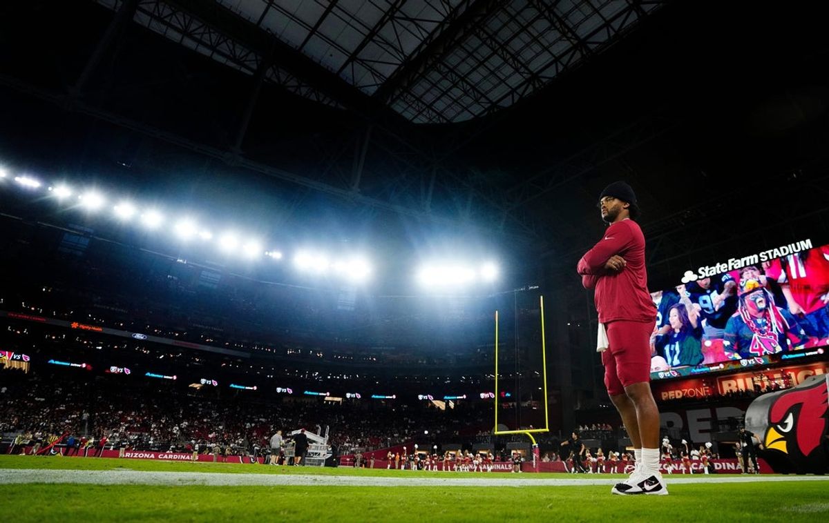 Cardinals quarterback Kyler Murray gets wired up on the sidelines during a preseason game against the Raiders at State Farm Stadium in Glendale on Aug. 23, 2025.