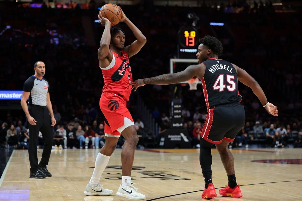 Dec 15, 2025; Miami, Florida, USA; Toronto Raptors guard Immanuel Quickley (5) protects the basketball against Miami Heat guard Davion Mitchell (45) during the first quarter at Kaseya Center. Mandatory Credit: Sam Navarro-Imagn Images