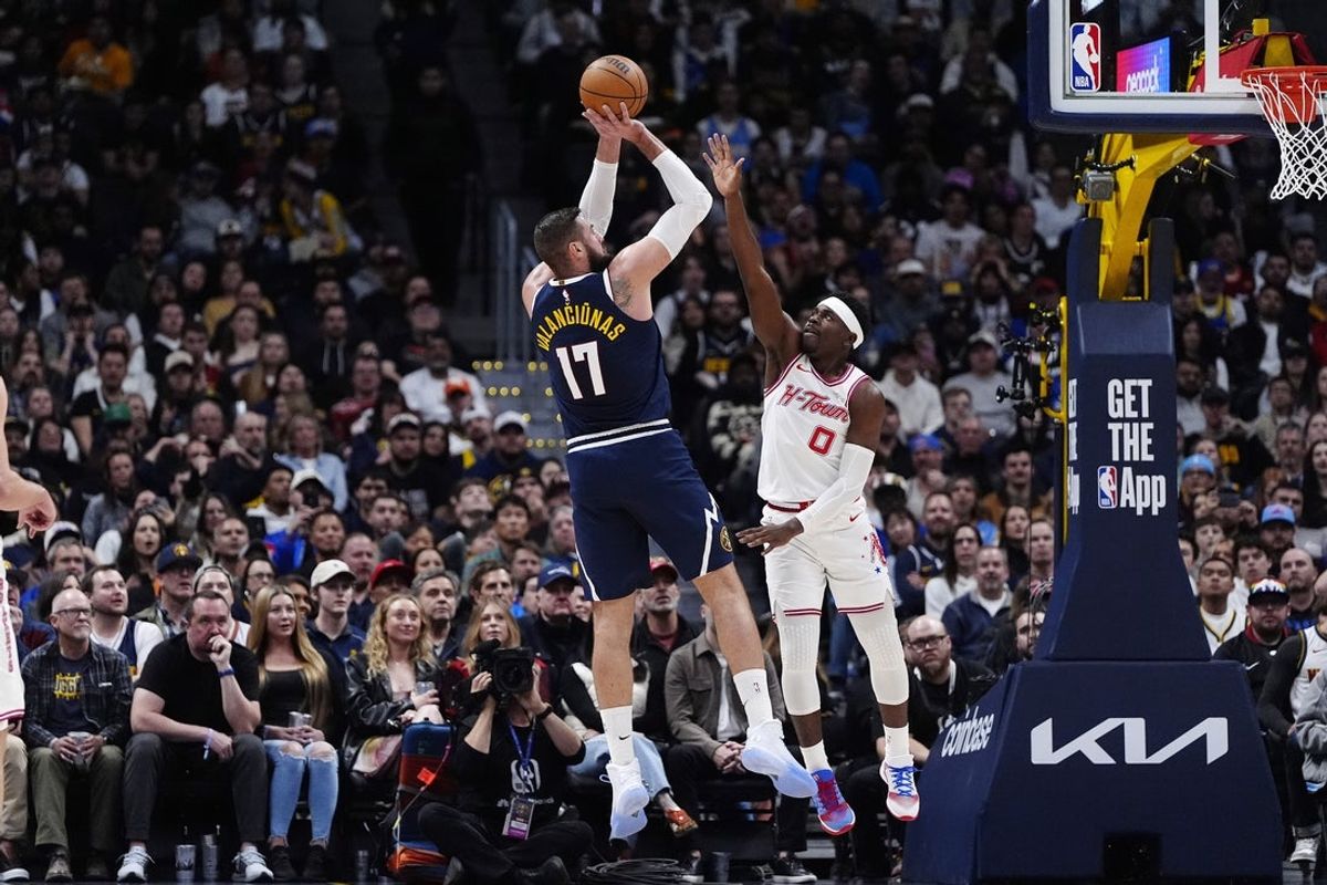 Dec 15, 2025; Denver, Colorado, USA; Denver Nuggets center Jonas Valanciunas (17) shoots over Houston Rockets guard Aaron Holiday (0) in the second quarter at Ball Arena. Mandatory Credit: Ron Chenoy-Imagn Images