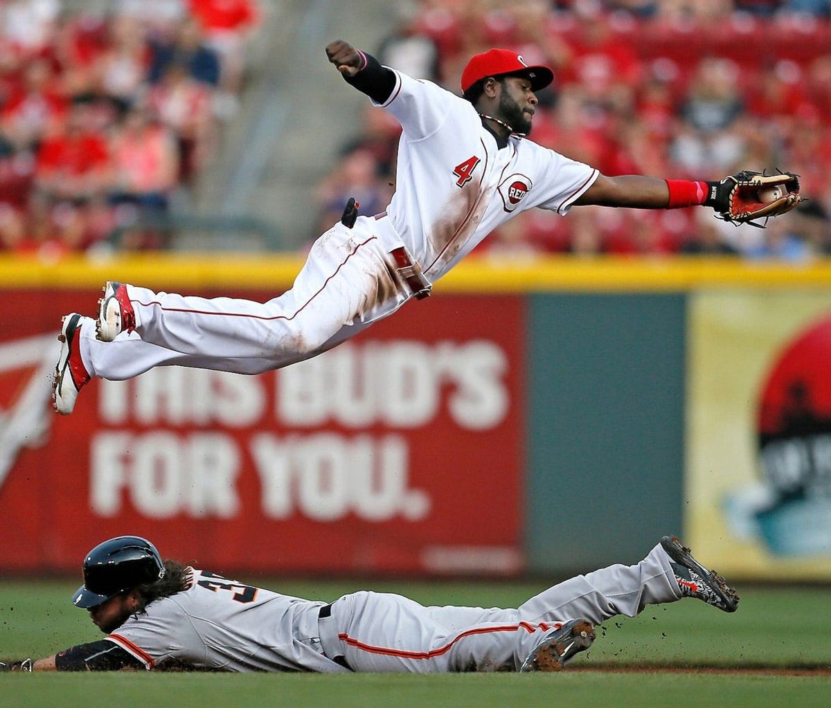 May 15, 2015: Reds second baseman Brandon Phillips (4) leaps to save a wild pick-off throw down to second base as San Francisco Giants shortstop Brandon Crawford (35) slides in safely on a steal.