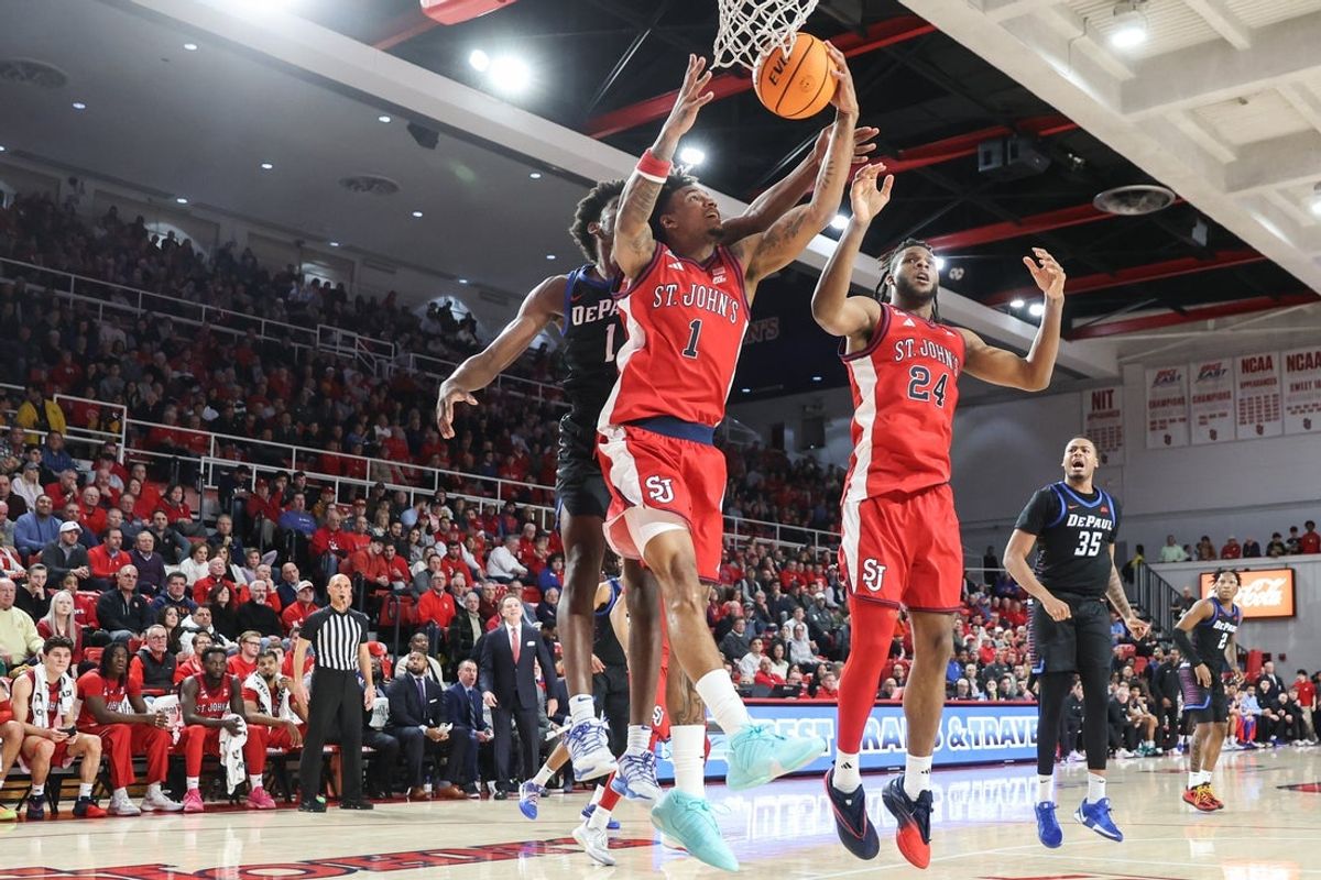 Dec 16, 2025; Queens, New York, USA; St. John's Red Storm forward Dillon Mitchell (1) grabs a rebound away from DePaul Blue Demons forward Kaleb Banks (1) in the first half at Carnesecca Arena. Mandatory Credit: Wendell Cruz-Imagn Images
