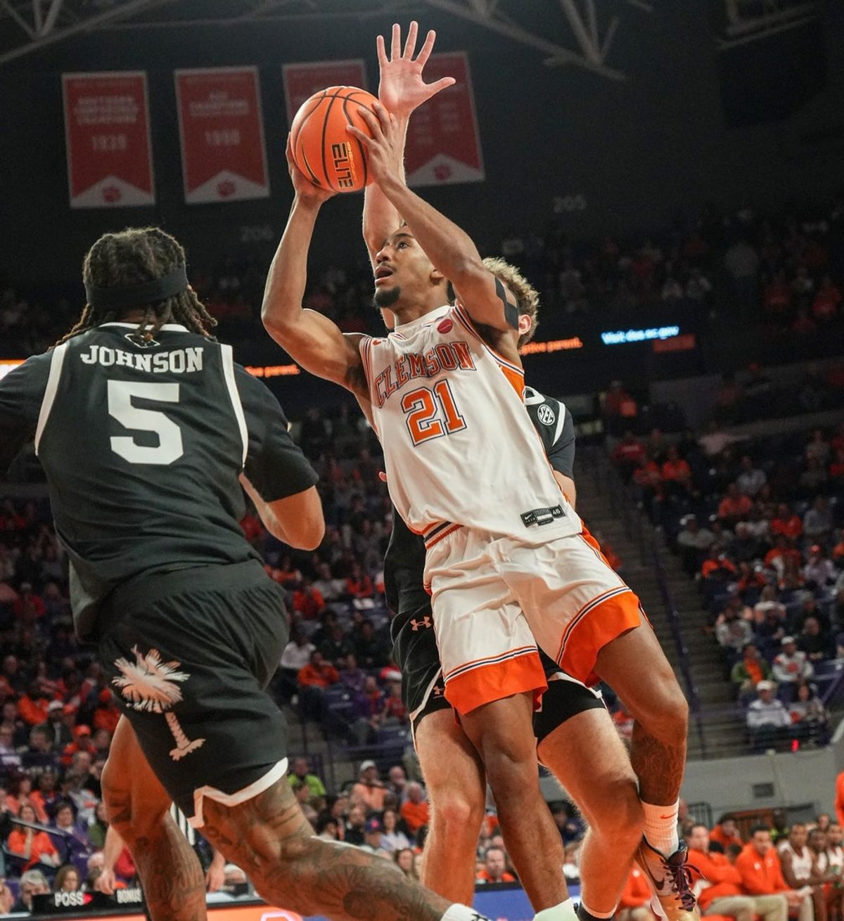 Clemson guard Ace Buckner(21) scores near South Carolina guard Meechie Johnson (5) during the first half at Littlejohn Coliseum in Clemson, S.C. Tuesday, Dec 16, 2025.