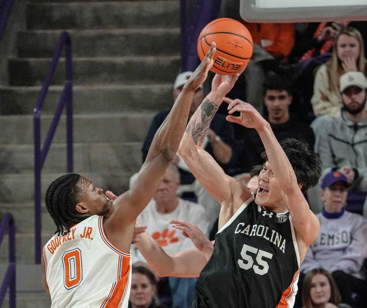 Clemson sophomore forward RJ Godfrey (0) and South Carolina guard Mike Sharavjamts (55) reach for a ball during the first half at Littlejohn Coliseum in Clemson, S.C. Tuesday, Dec 16, 2025.