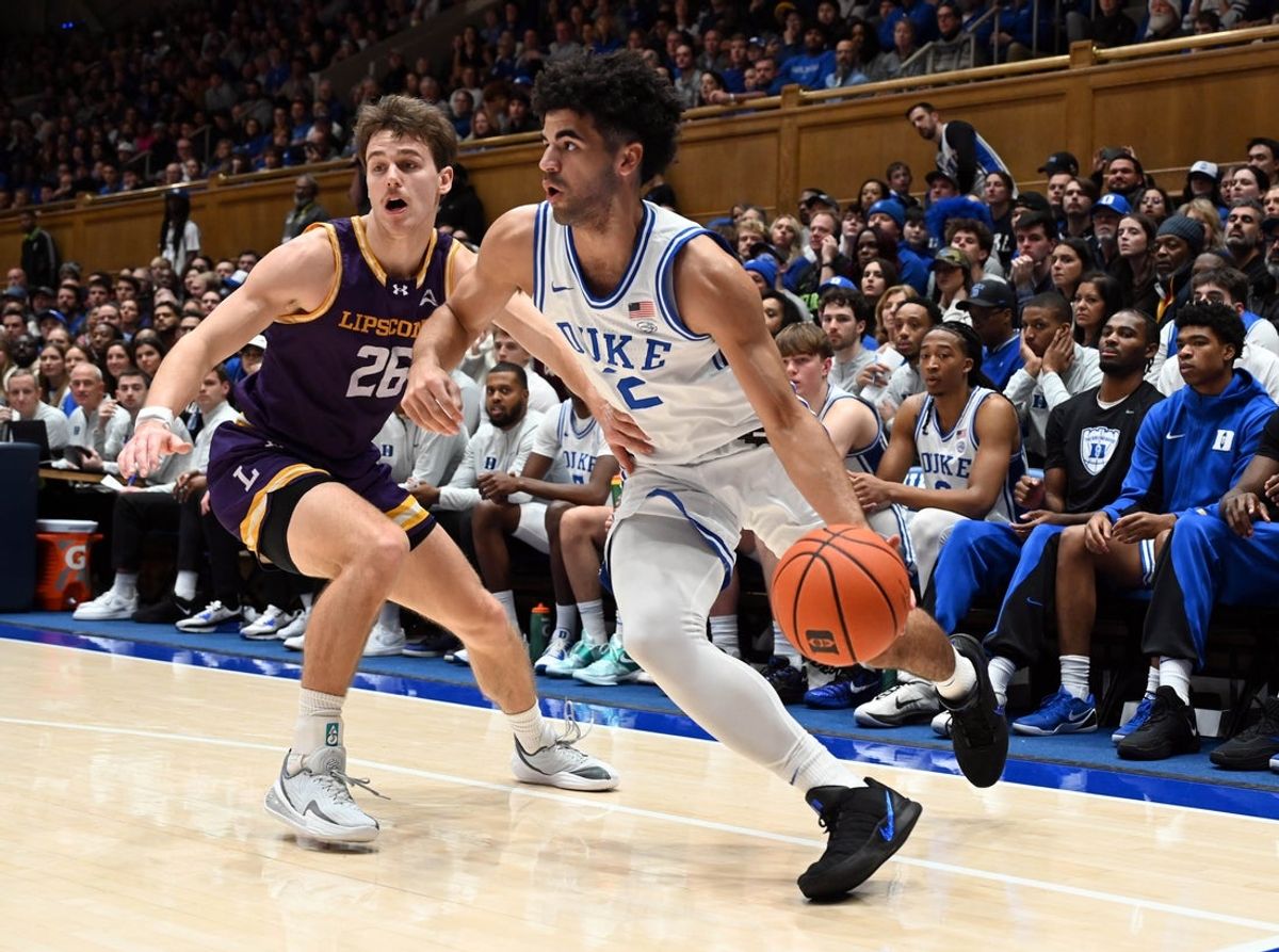 Dec 16, 2025; Durham, North Carolina, USA; Duke Blue Devils guard Cayden Boozer (2) drives to the basket past Lipscomb Bisons forward Titas Sargiunas (26) during the second half at Cameron Indoor Stadium. The Blue Devils won 97-73.  Mandatory Credit: Rob Kinnan-Imagn Images